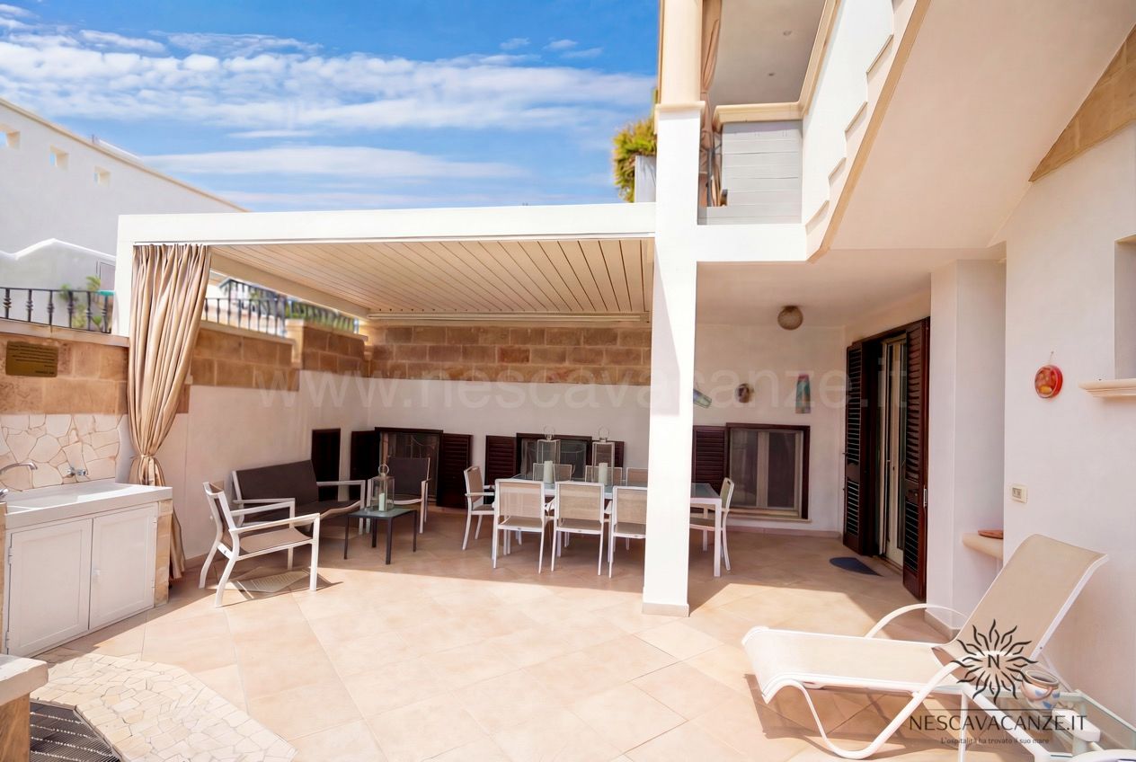 Casa Pescoluse 2 - patio con pergola, tavolo da pranzo, lettini e giardino con palme
