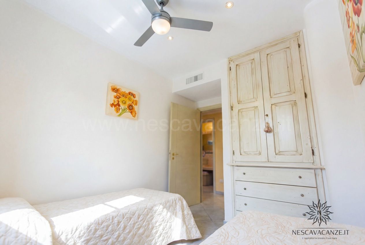 Casa Pescoluse 7 - cameretta con armadio bianco, ventilatore a soffitto e accesso al bagno