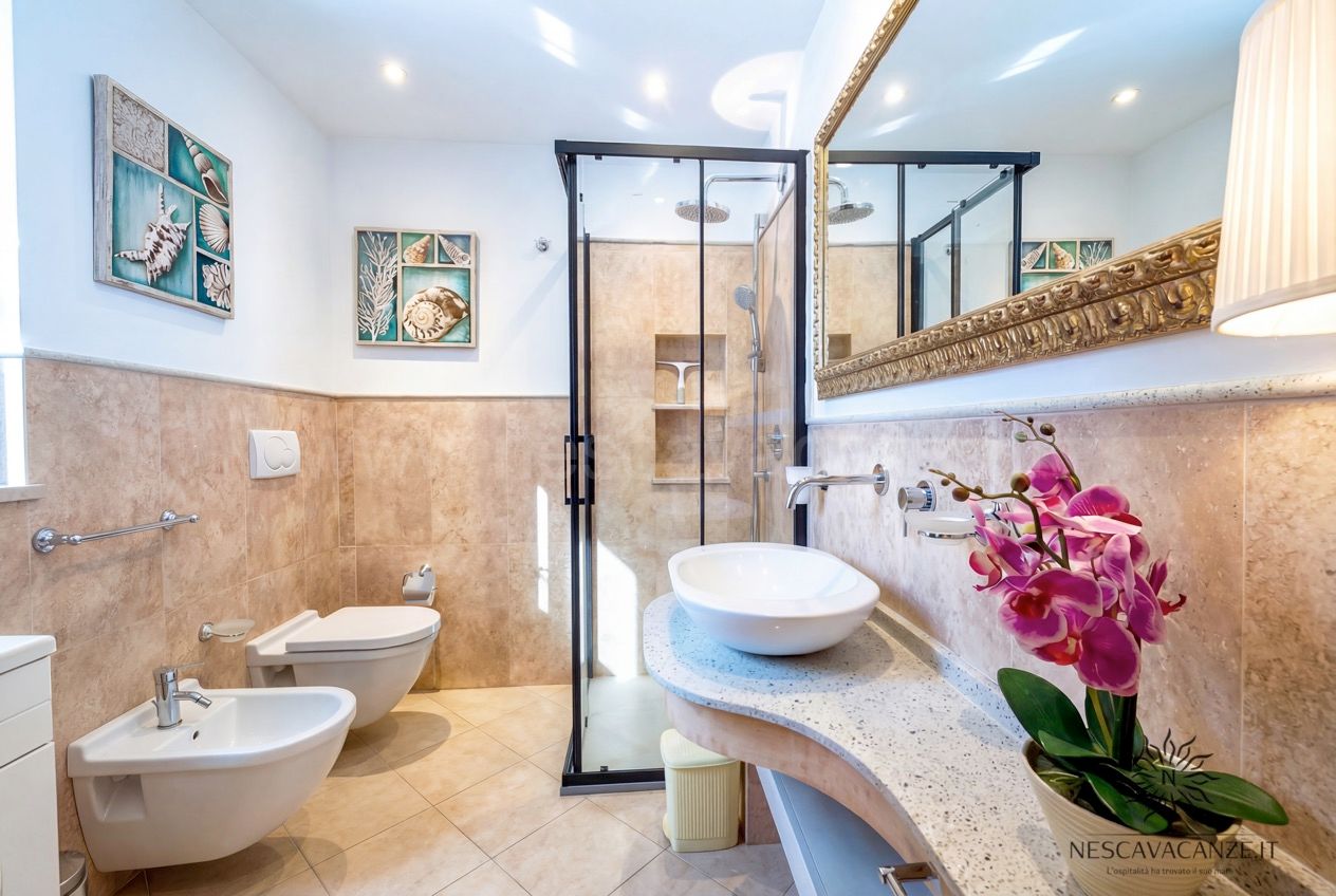 Casa Pescoluse 8 - Bagno con doccia in vetro, lavabo da appoggio, wc, bidet e quadri a tema marino