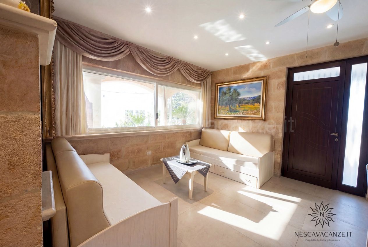 Casa Pescoluse 1 - salottino con due divani beige, finestra e quadro con paesaggio
