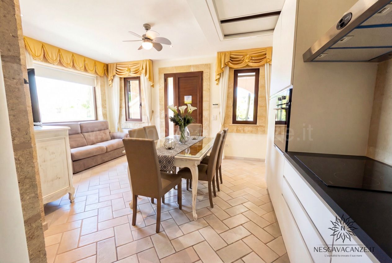 Casa Pescoluse 4 - angolo cottura bianco, tavolo da pranzo, divano, TV e tende gialle