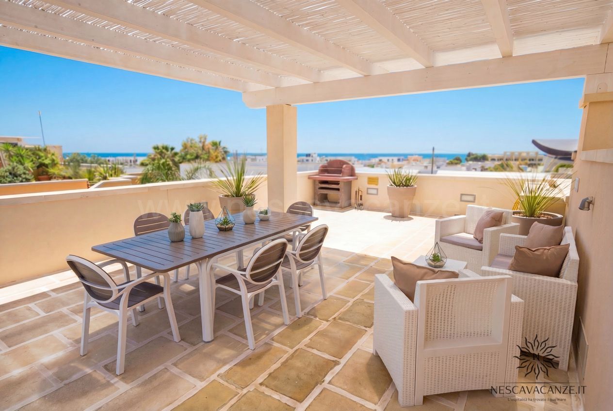 Casa Giglio - terrazza con tavolo da pranzo e sedie, area salotto, barbecue e vista mare in lontananza