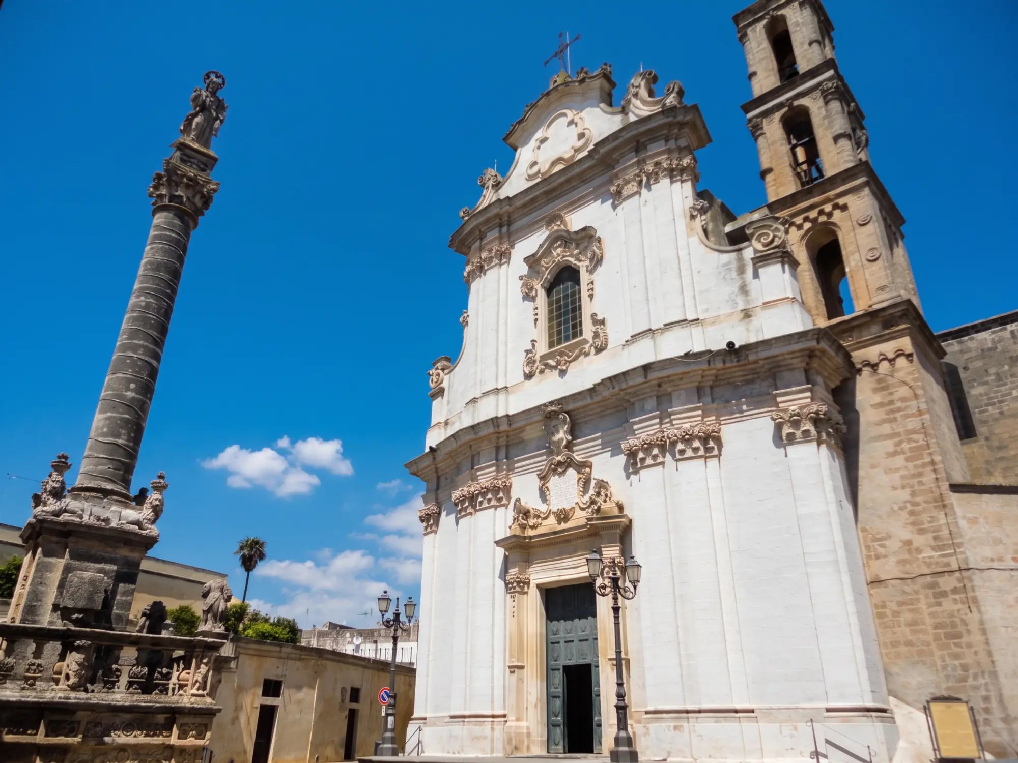 La chiesa madre di Sant'Andrea a Presicce, barocca e bianca, con la colonna votiva del santo accanto alla facciata