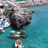 L'acqua turchese del porticciolo di Castro Marina, con le barche e lo scoglio