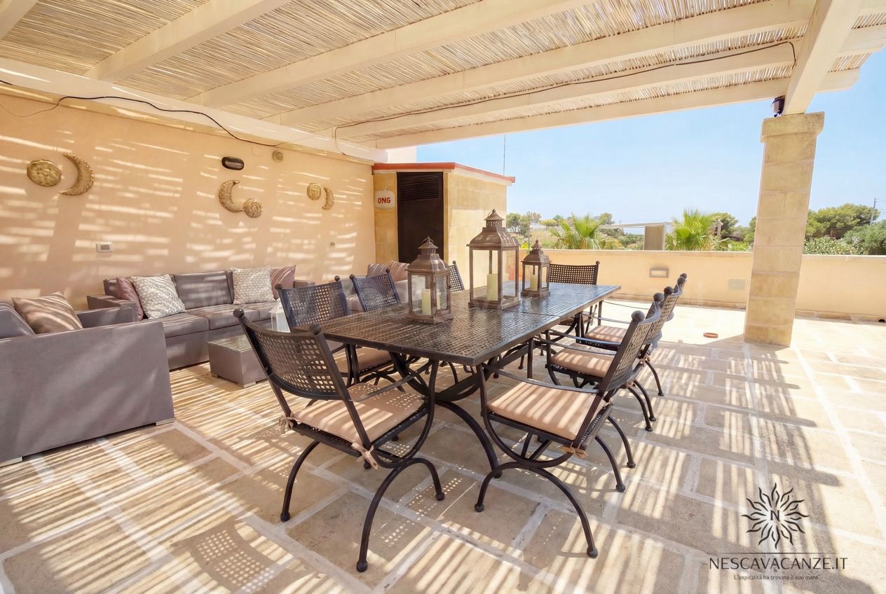 Casa Pescoluse 4 - terrazza con pergolato, tavolo e sedie in ferro, lanterne, divani e vista mare