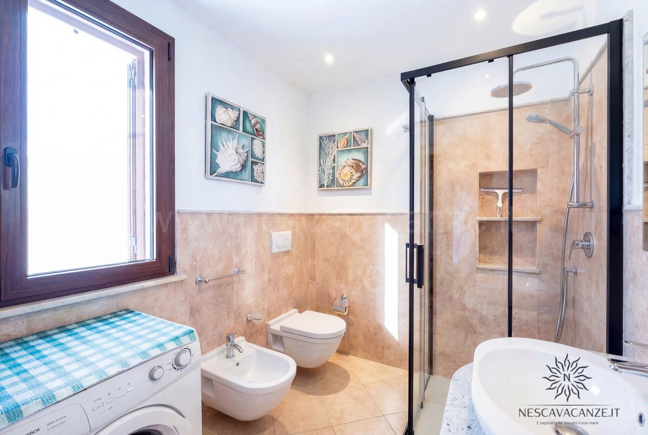 Casa Pescoluse 8 - Bagno con doccia, wc, bidet, lavatrice e finestra, decori a tema conchiglie