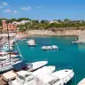 Il porticciolo di Tricase Porto con l'acqua turchese, le barche e la villa rossa