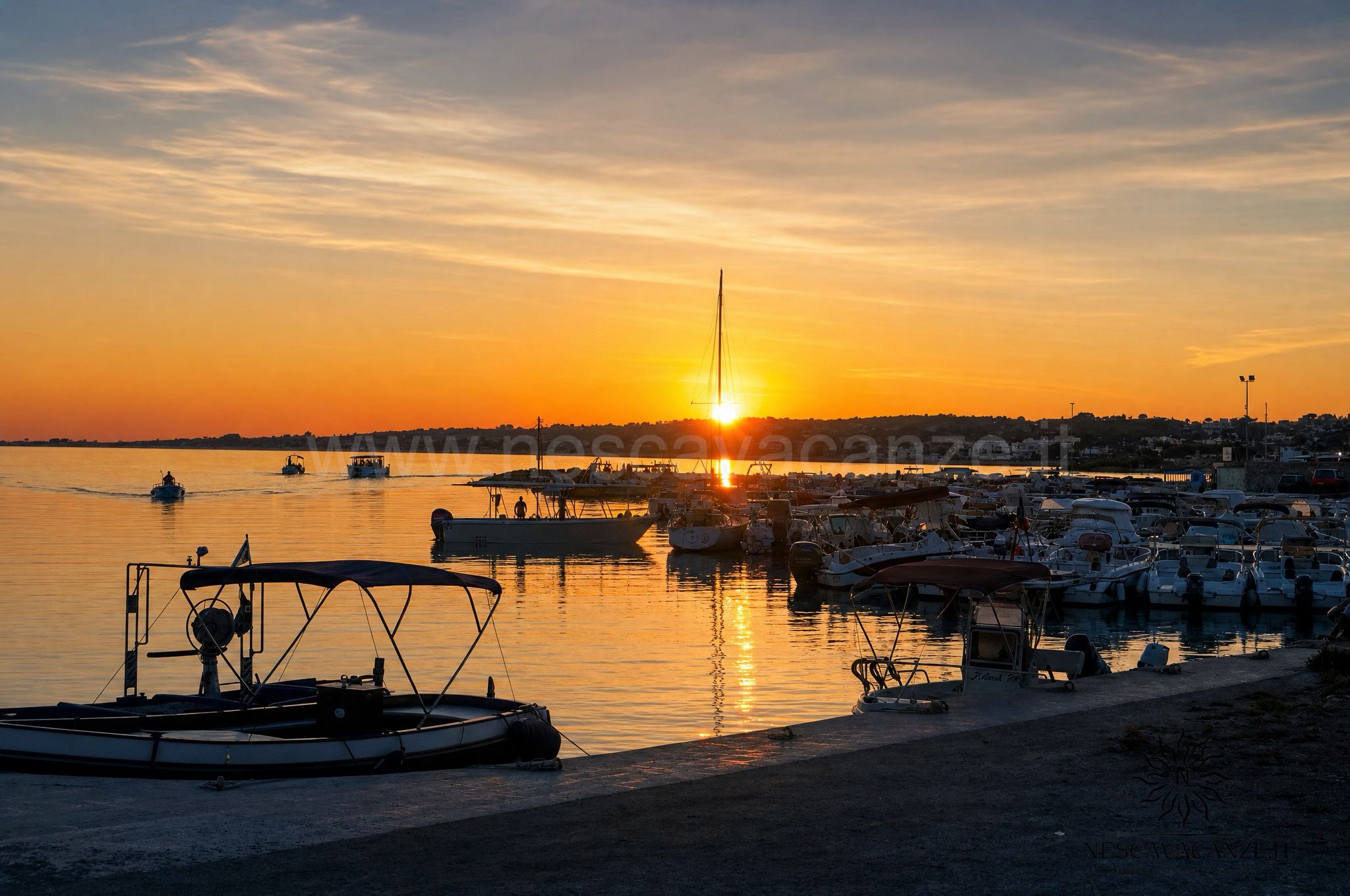 Tramonto dorato sul porto di Torre Vado con le barche ormeggiate