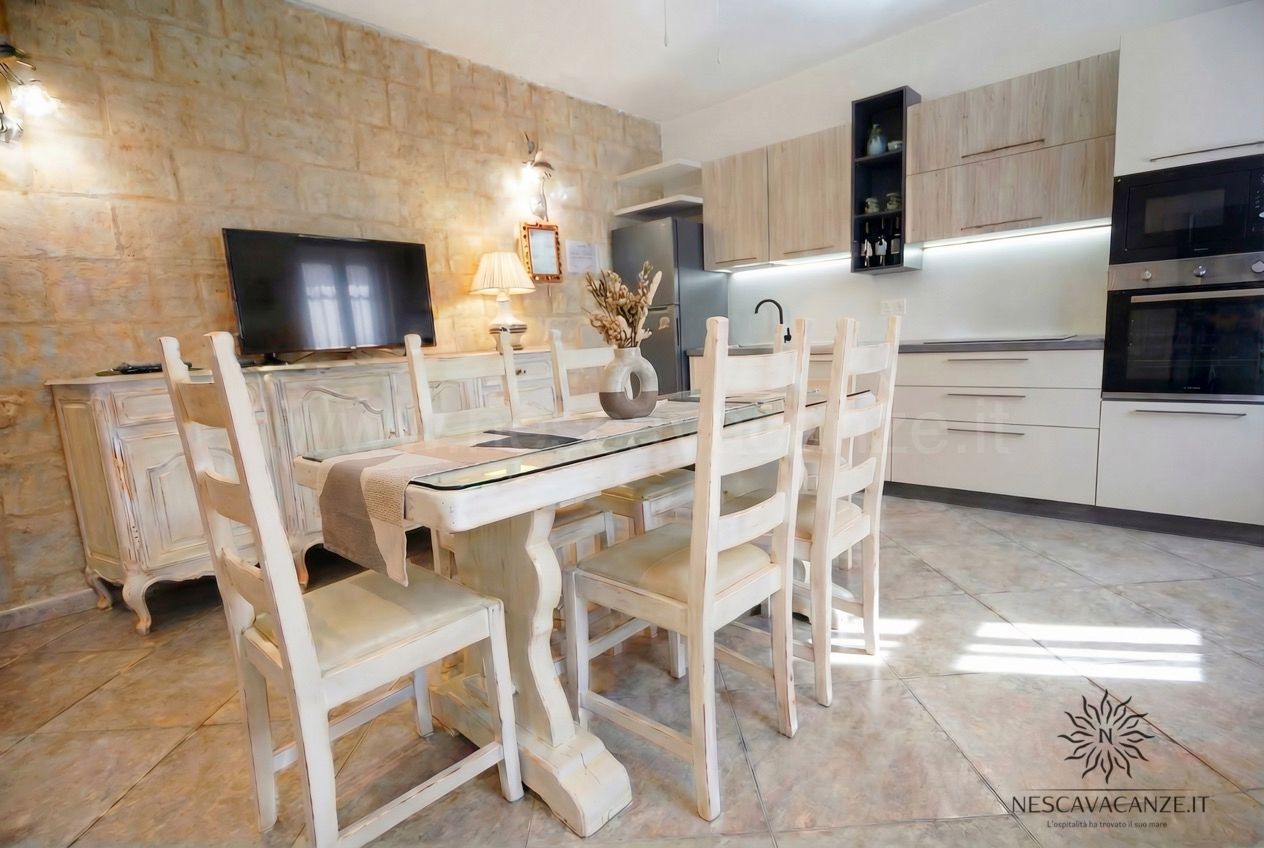 Casa Pescoluse 7 - cucina attrezzata con tavolo, TV, forno e frigo, parete in pietra