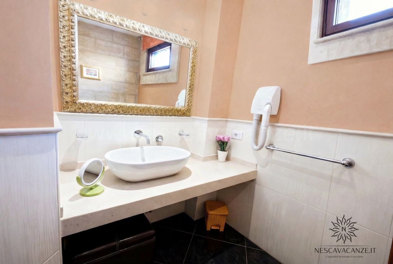 Casa Pescoluse 4 - bagno con lavabo ovale da appoggio, piano in marmo, specchio dorato e asciugacapelli