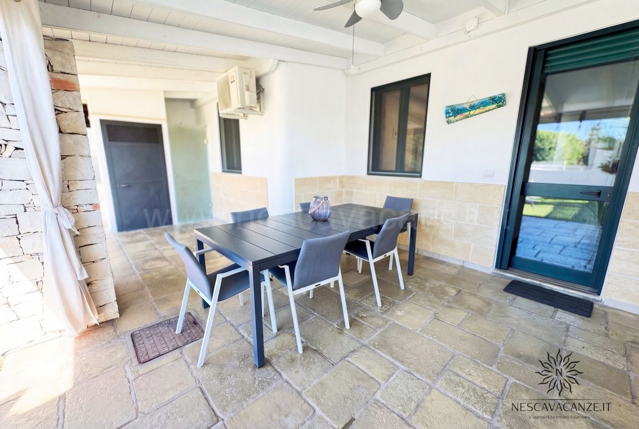 Casa Sabbia Oro - veranda coperta con tavolo da pranzo, sei sedie, ventilatore a soffitto e porta-finestra