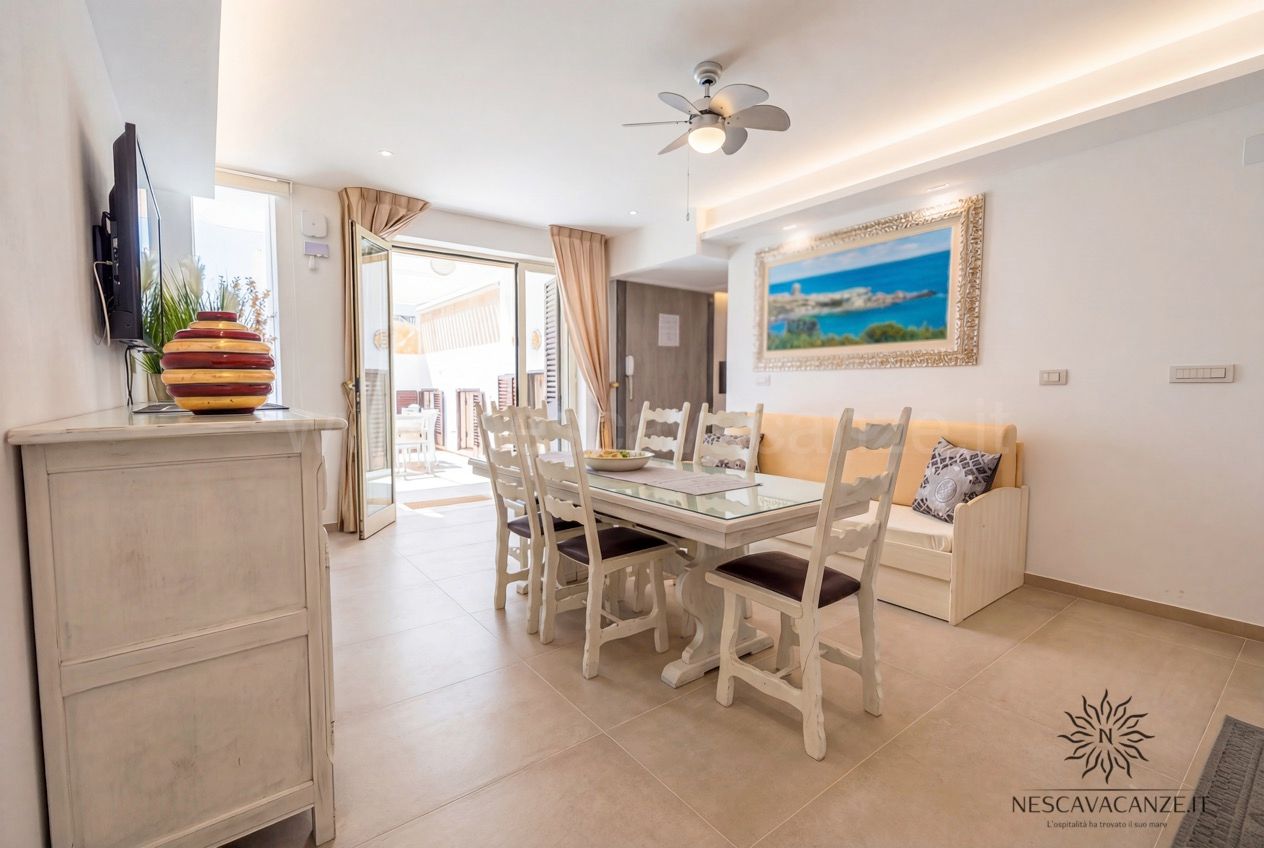 Casa Pescoluse 2 - soggiorno con credenza, TV, tavolo da pranzo, divano e quadro del mare