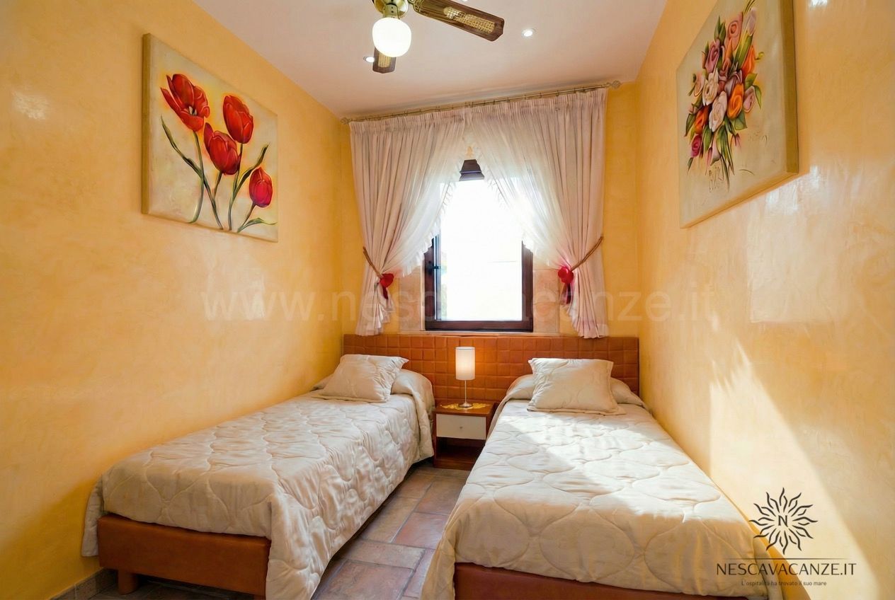 Casa Pescoluse 5 - camera con due letti singoli, pareti gialle e quadri di fiori