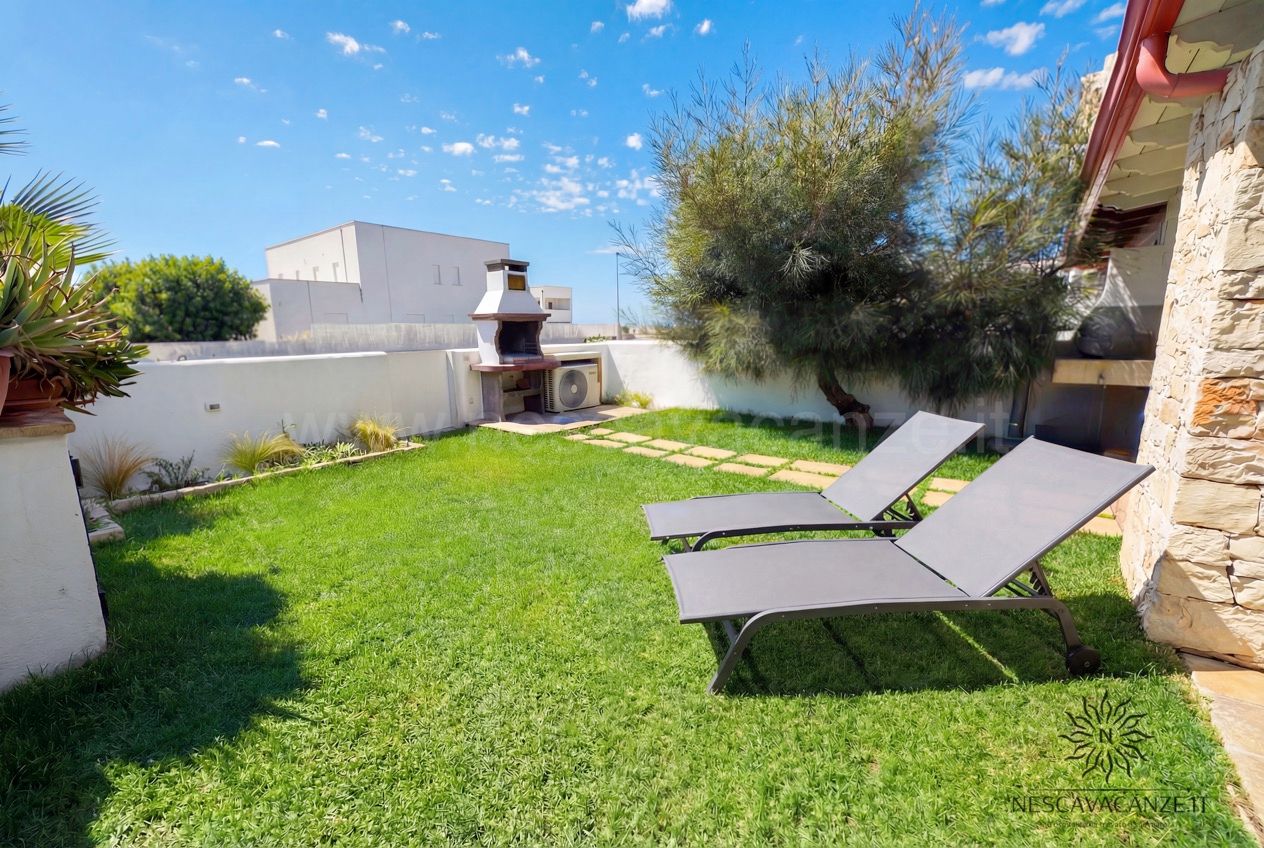 Casa Sabbia Oro - giardino con prato, due lettini prendisole, barbecue in muratura e ulivo