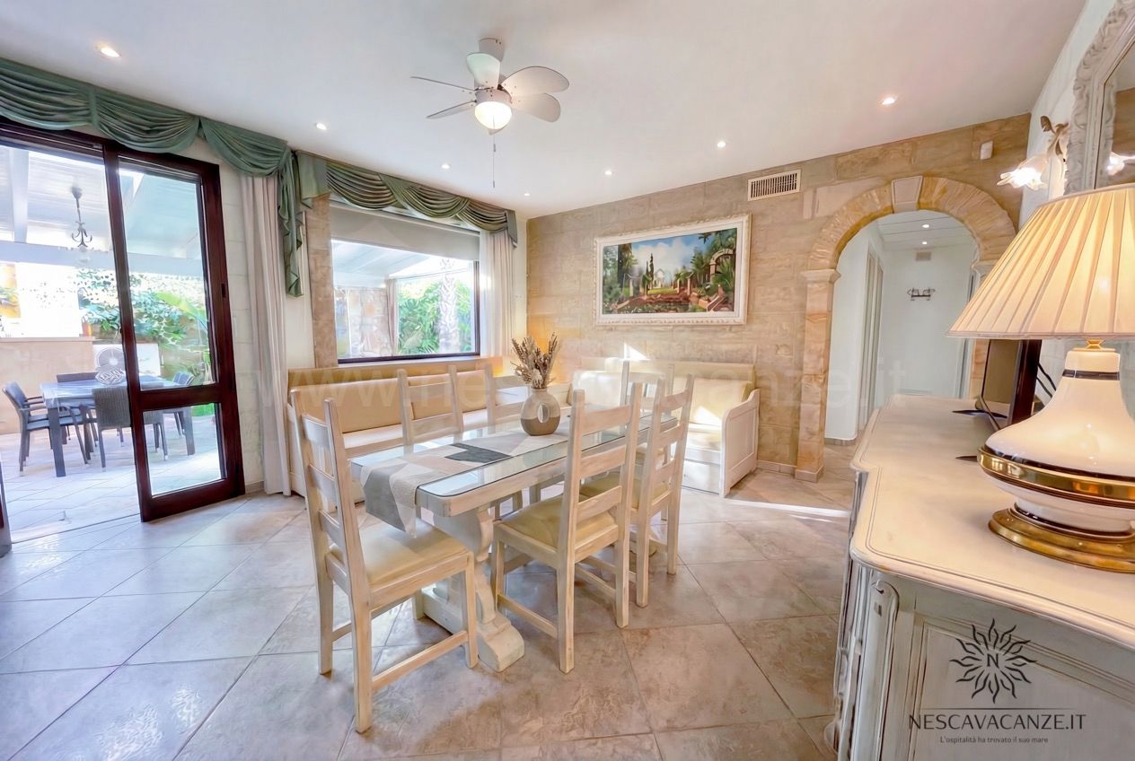 Casa Pescoluse 7 - sala da pranzo interna con tavolo in legno, arco in pietra e quadro