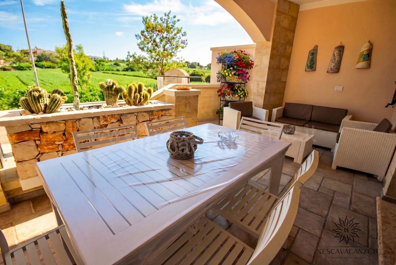 Casa Pescoluse 5 - veranda coperta con tavolo, sedie e divani, vista campagna e cactus
