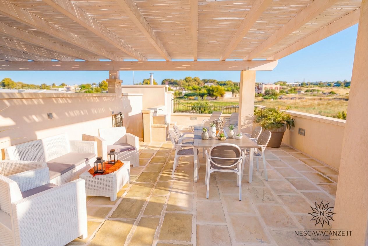 Casa Giglio - terrazzo con pergolato in canne, divani in rattan, tavolo e vista campagna