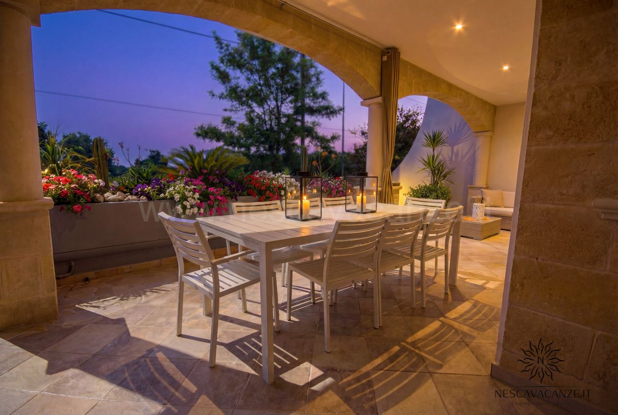 Casa Pescoluse 1 - veranda con tavolo da pranzo al tramonto, candele accese e fiori