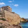 La Torre dell'Ovo sugli scogli, con il mare blu sotto
