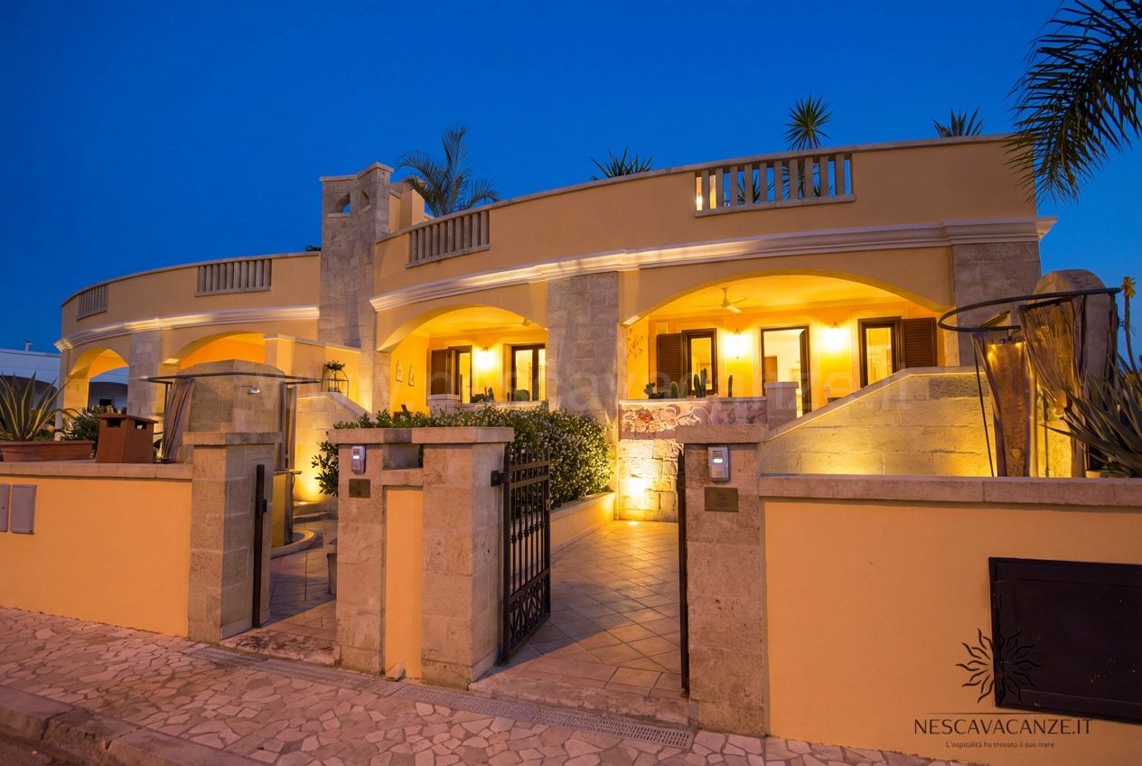 Casa Pescoluse 5 - esterno della villa illuminata al tramonto, archi e cancello d'ingresso