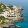 Marina Serra dall'alto: la costa rocciosa, la torre e il mare blu profondo