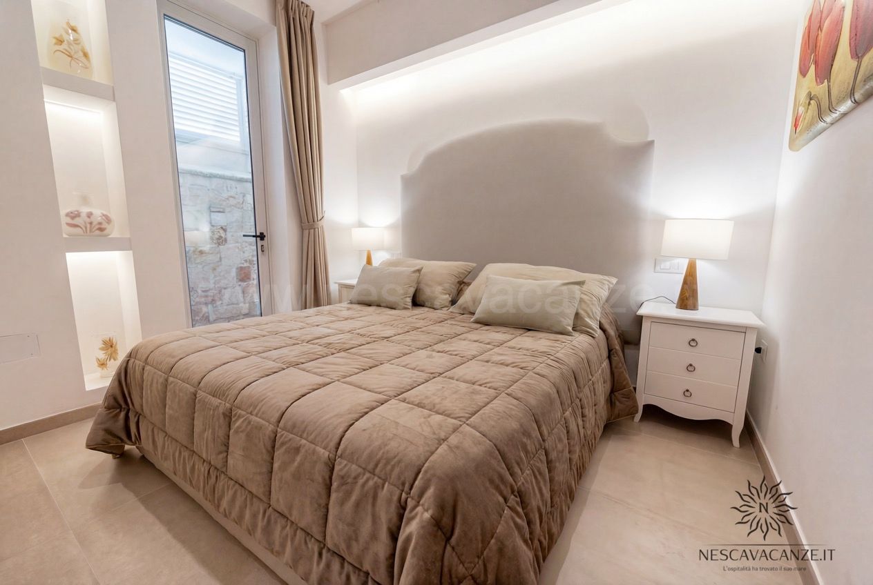 Casa Pescoluse 2 - camera matrimoniale con copriletto tortora, comodino bianco e lampade