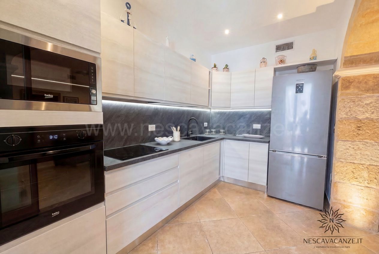 Casa Pescoluse 9 - cucina moderna con mobili chiari, piano a induzione, forni e frigorifero