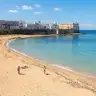 La spiaggia della Purità a Gallipoli, con il mare turchese e le case del centro storico