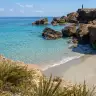 Piccola spiaggia di sabbia tra gli scogli a Specchiolla, con il mare turchese
