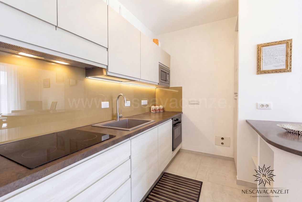 Casa Pescoluse 3 - angolo cottura lineare con piano a induzione, forno, lavello, microonde e pensili bianchi
