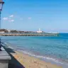 Il lungomare di San Cataldo con la spiaggia, le onde e il faro sullo sfondo
