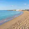 Spiaggia di sabbia a Frigole con il mare che arriva a riva