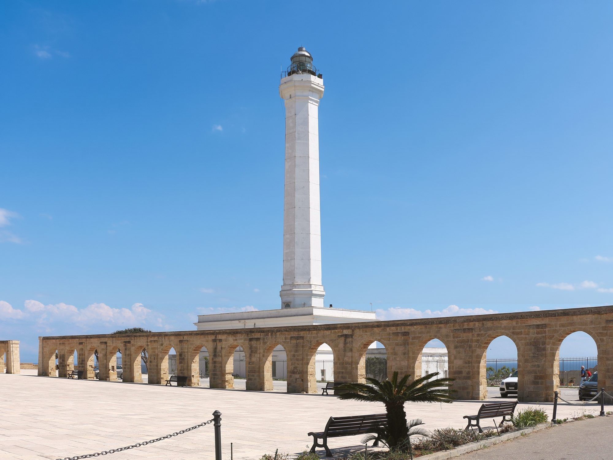 La torre del faro di Leuca dietro gli archi in pietra del piazzale del santuario