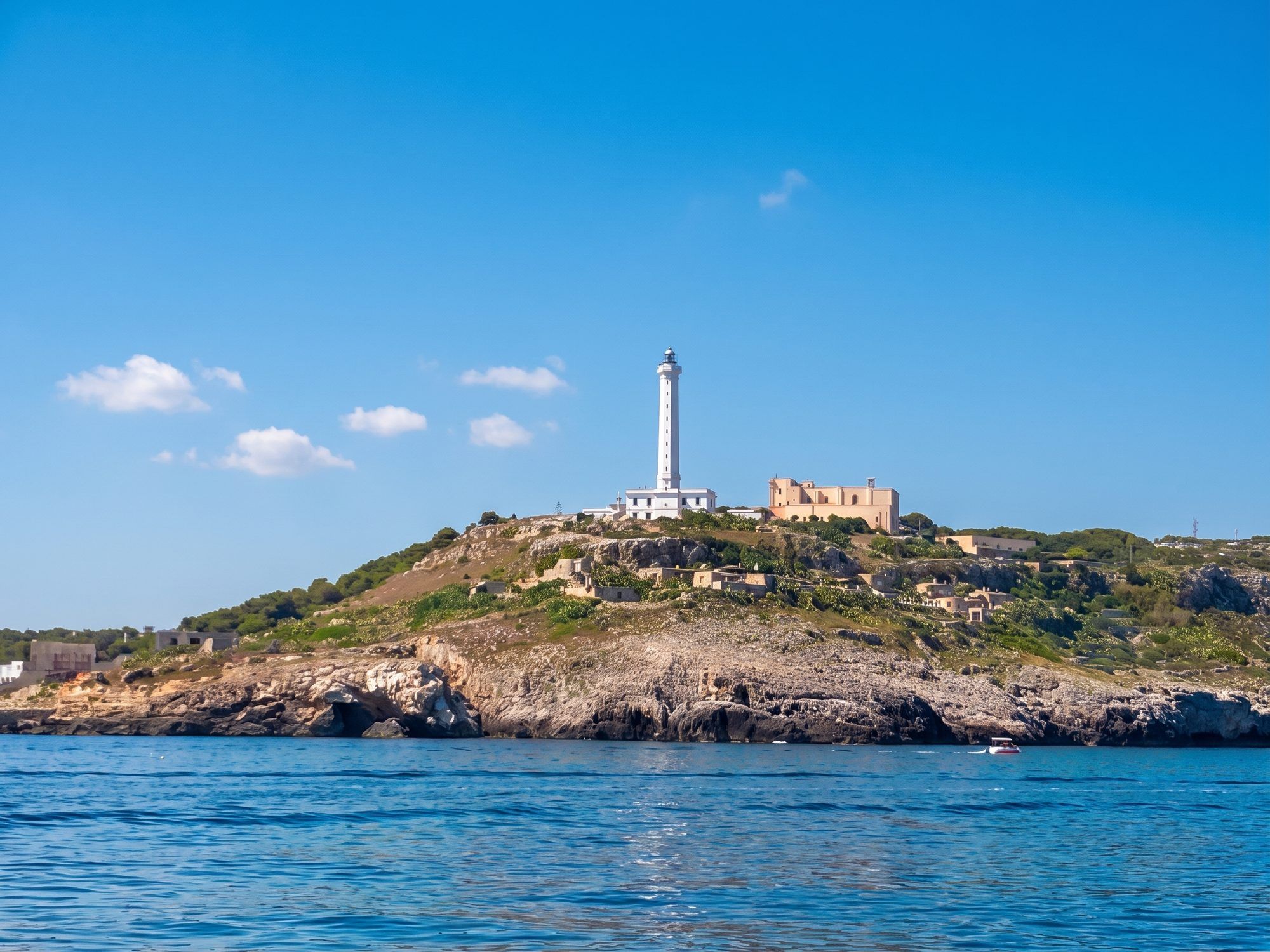 Il faro bianco di Santa Maria di Leuca sopra la scogliera di Punta Meliso, visto dal mare