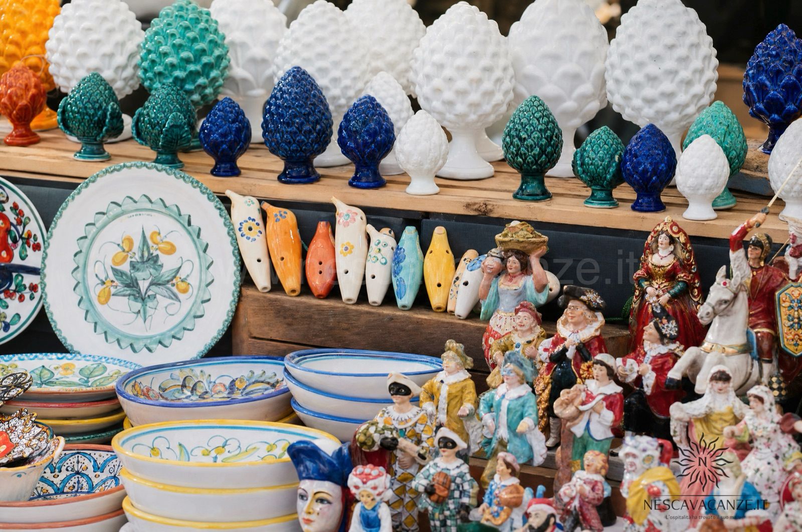 Banco di artigianato salentino con ceramiche di Grottaglie e figure in cartapesta leccese a un mercatino del Salento