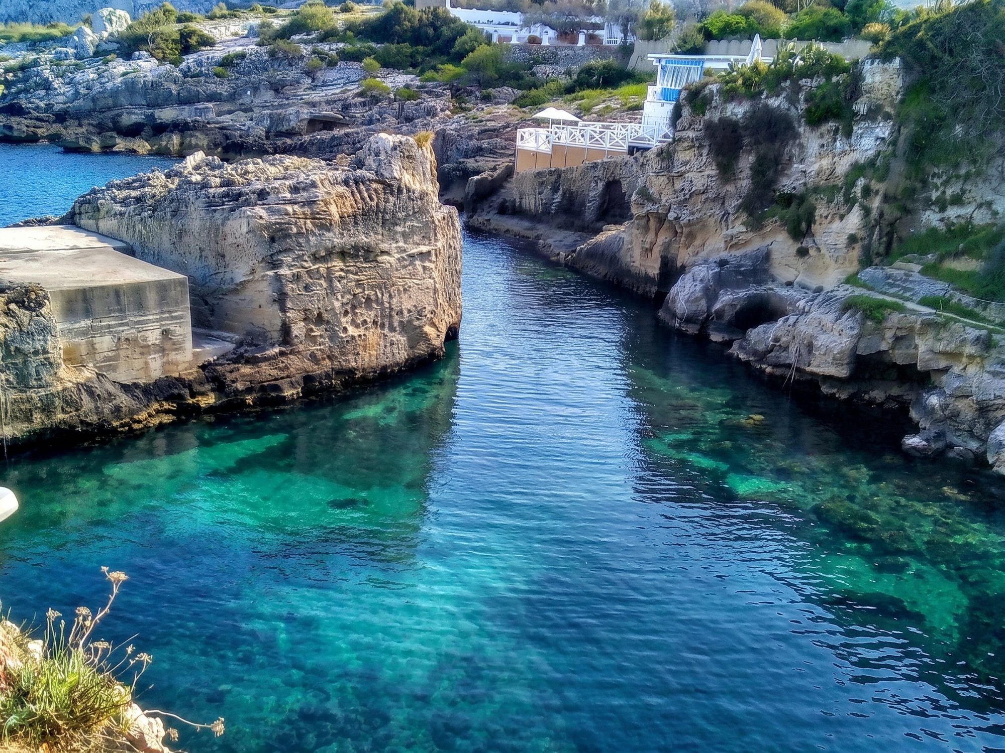 Il porticciolo di Novaglie scavato nella roccia, con l'acqua blu ferma tra le pareti e le case in alto