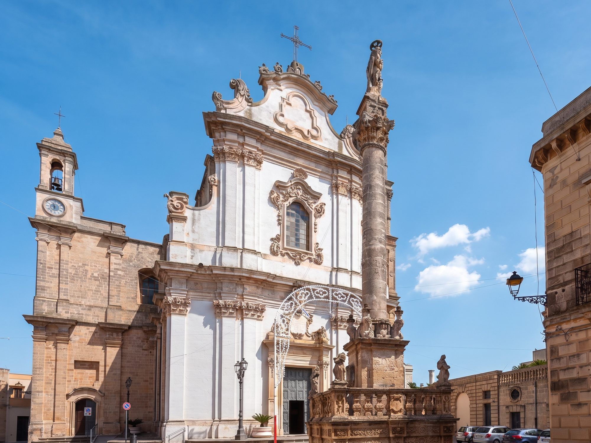 La chiesa madre di Sant'Andrea a Presicce, bianca e barocca, con la colonna del santo sulla piazza lastricata