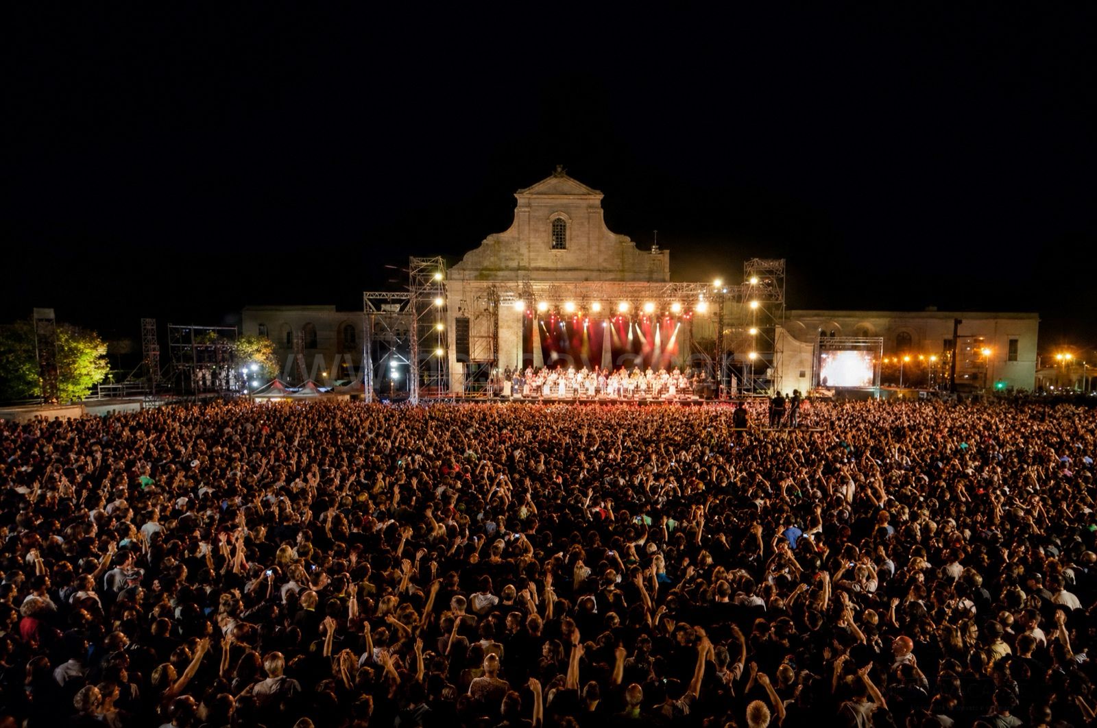 La folla del Concertone della Notte della Taranta a Melpignano di notte davanti al palco illuminato, in Salento