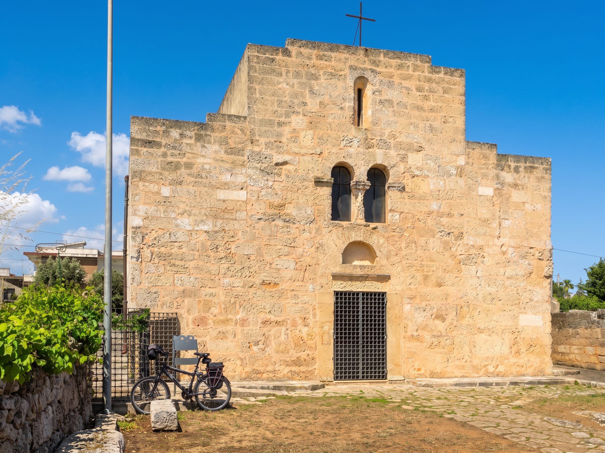 La facciata in pietra chiara della chiesa di San Giovanni Battista a Patù, con la bifora