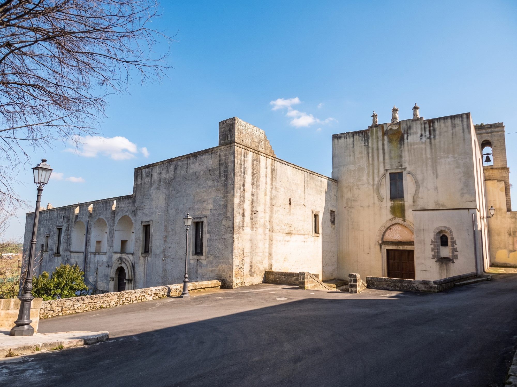La chiesa e il convento dei Francescani Neri a Specchia, con le mura bianche e il piazzale davanti