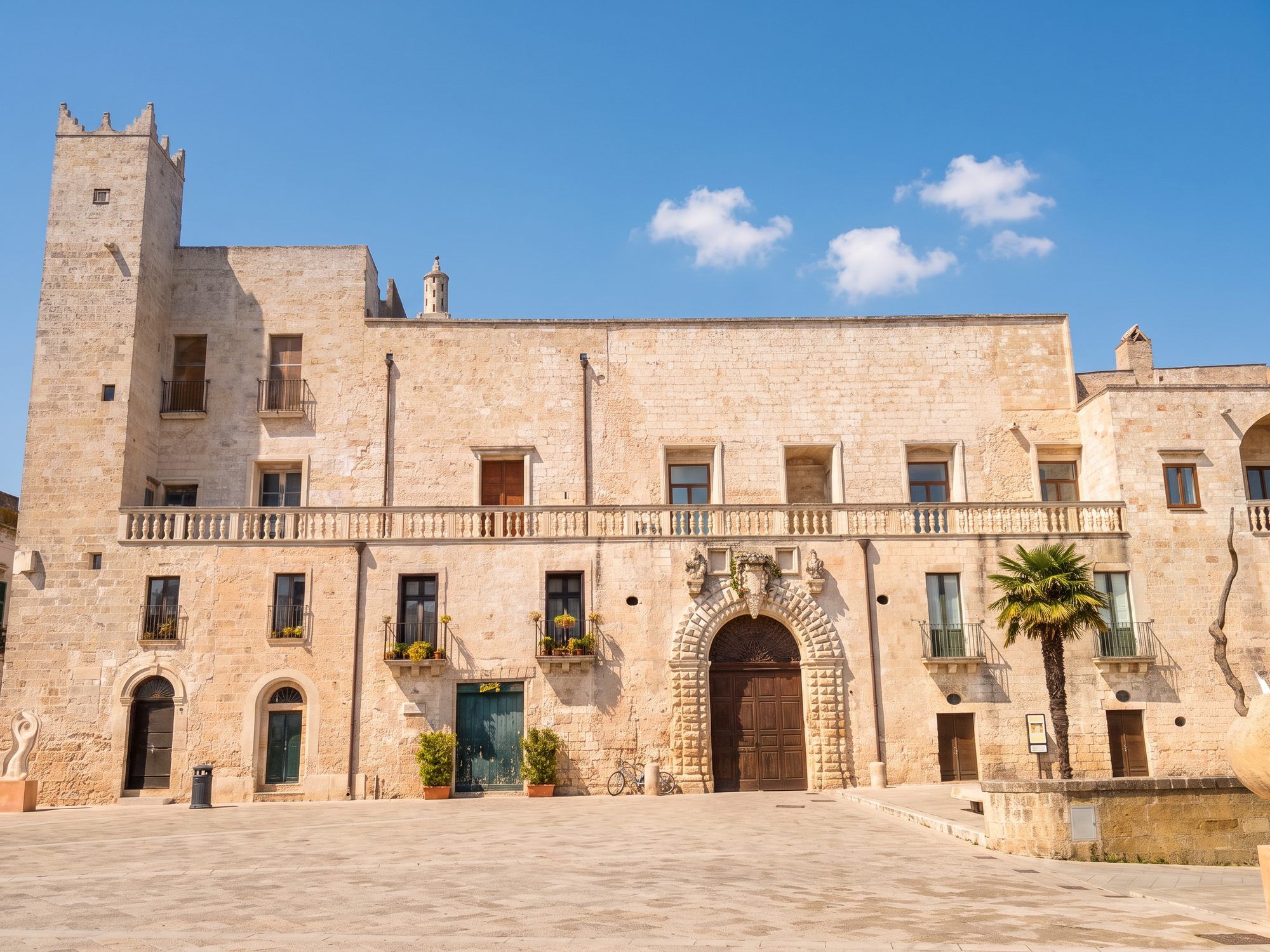 Palazzo Risolo a Specchia, in pietra chiara, con la torre merlata a sinistra e il portale bugnato sulla piazza