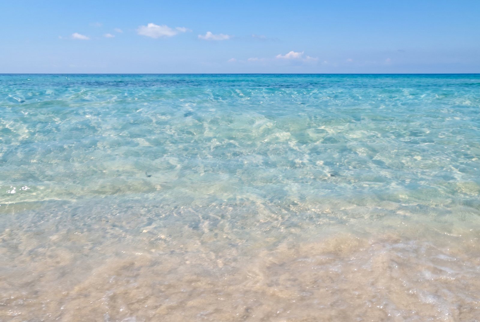 Acqua bassa e trasparente sulla riva di Pescoluse, con il fondale di sabbia chiara