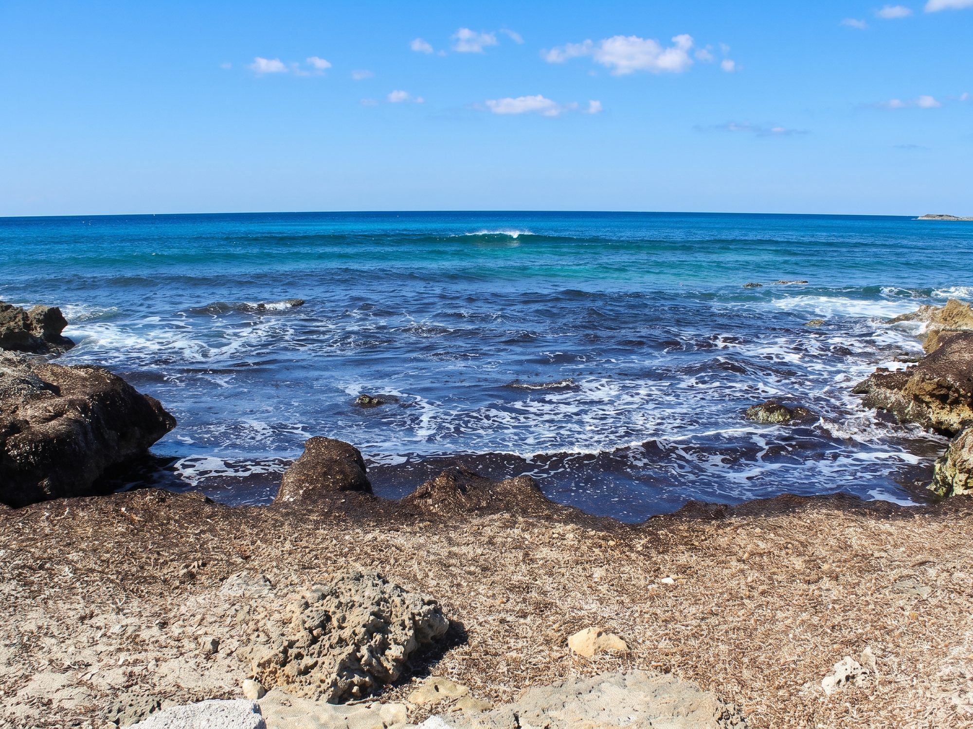 Piccola cala tra gli scogli di Torre San Giovanni, con le onde bianche sul mare azzurro