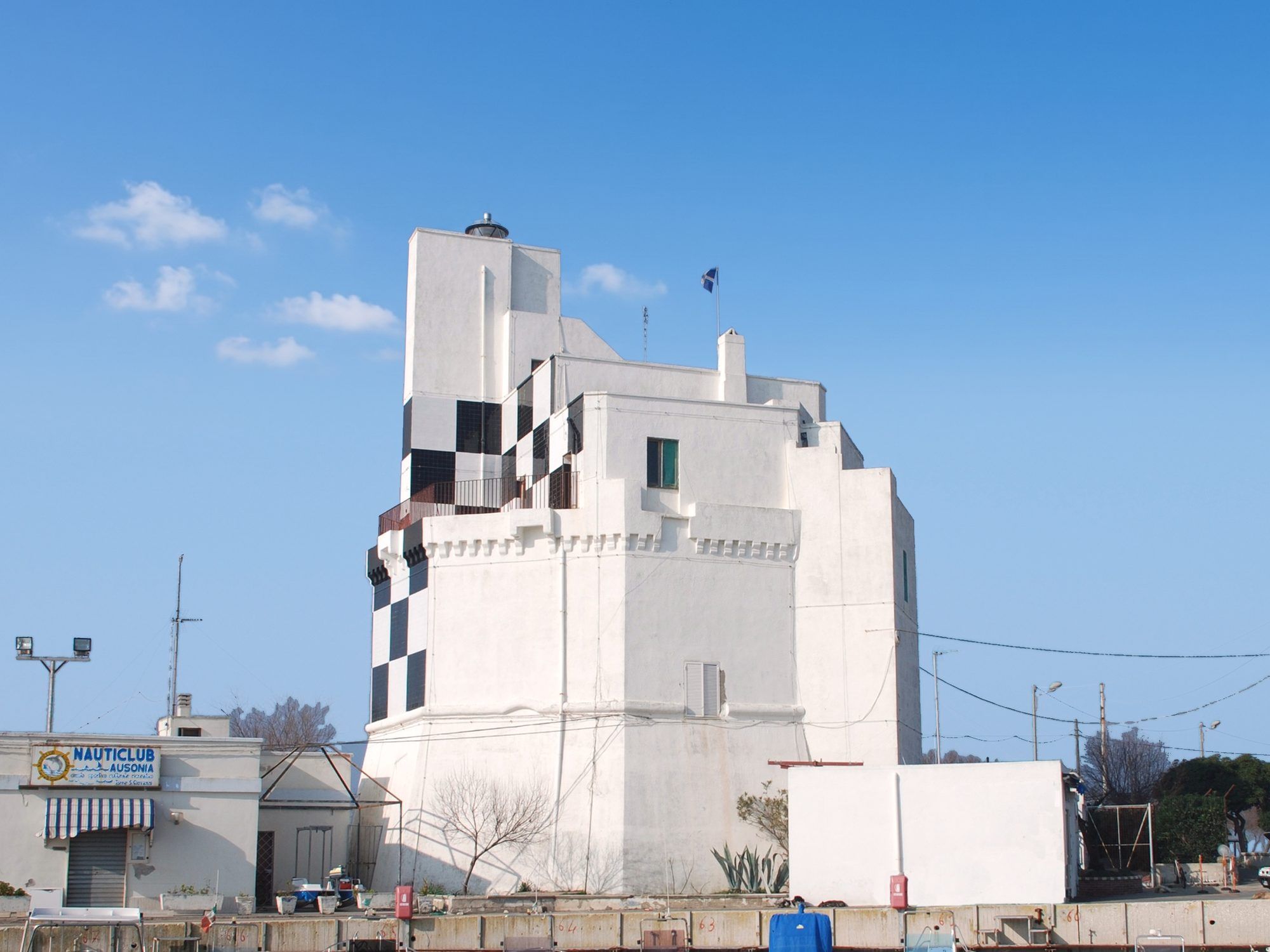 La torre di Torre San Giovanni con il faro sulla cima e i quadri bianchi e neri, sotto il cielo azzurro